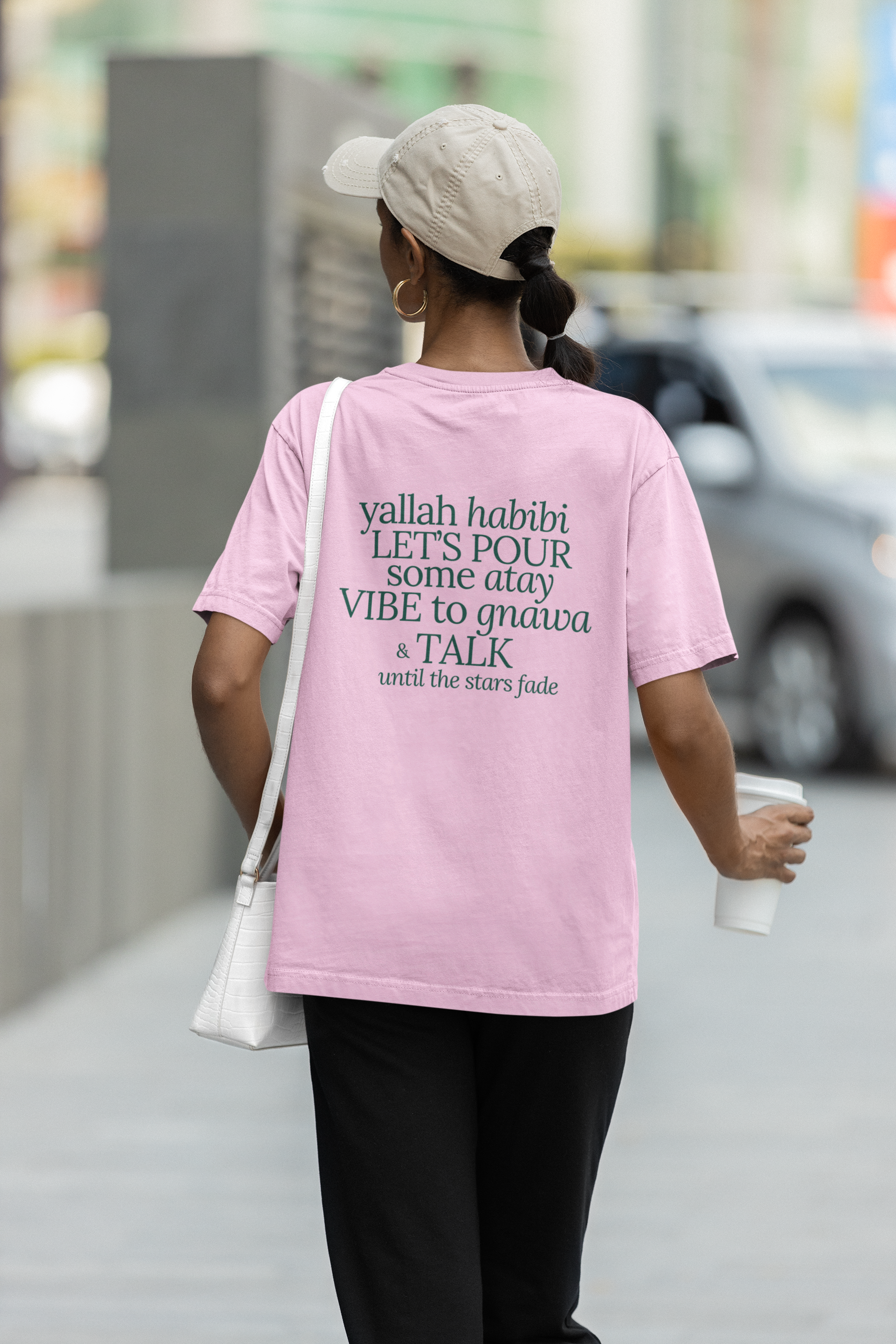 Back view of a T-shirt mockup featuring a woman walking in the street. Casual and stylish look, ideal for everyday fashion and streetwear.