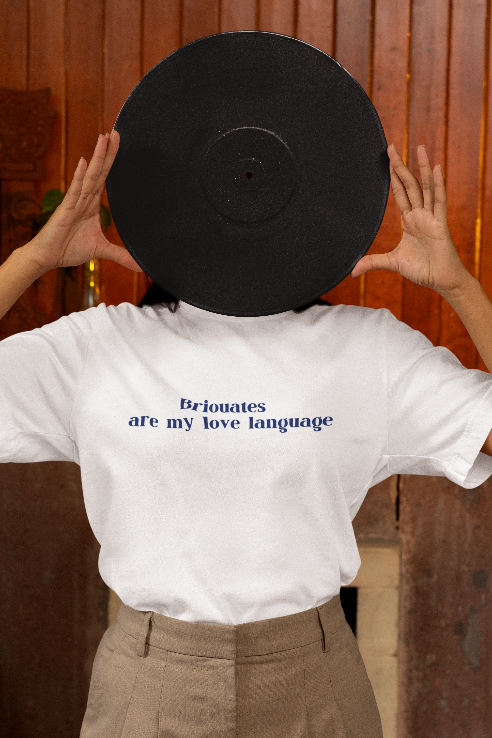 T-shirt mockup featuring a woman covering her face with a vinyl. Trendy and artistic look, perfect for music lovers and modern casual fashion