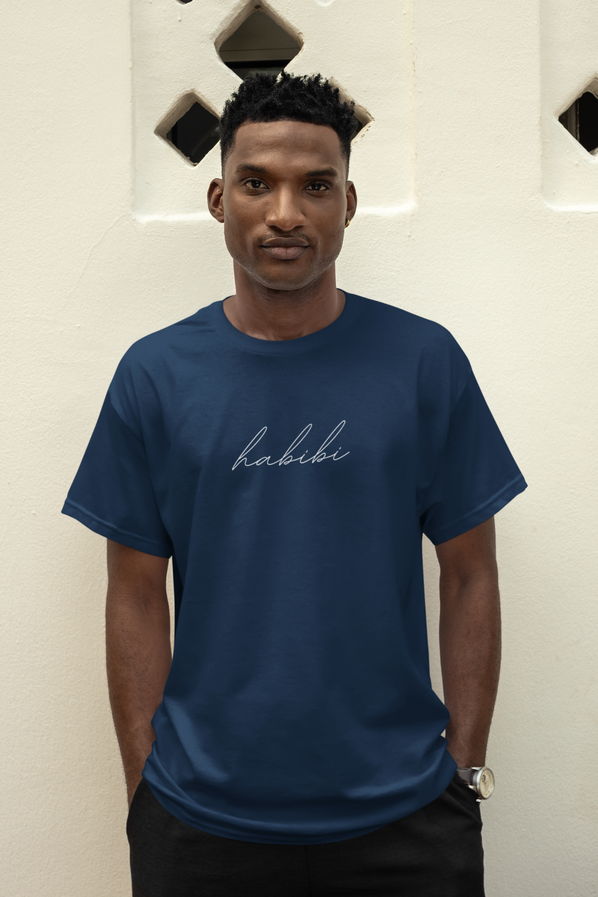 Man wearing a navy blue “Habibi” T-shirt with a minimalist Arabic cursive design.