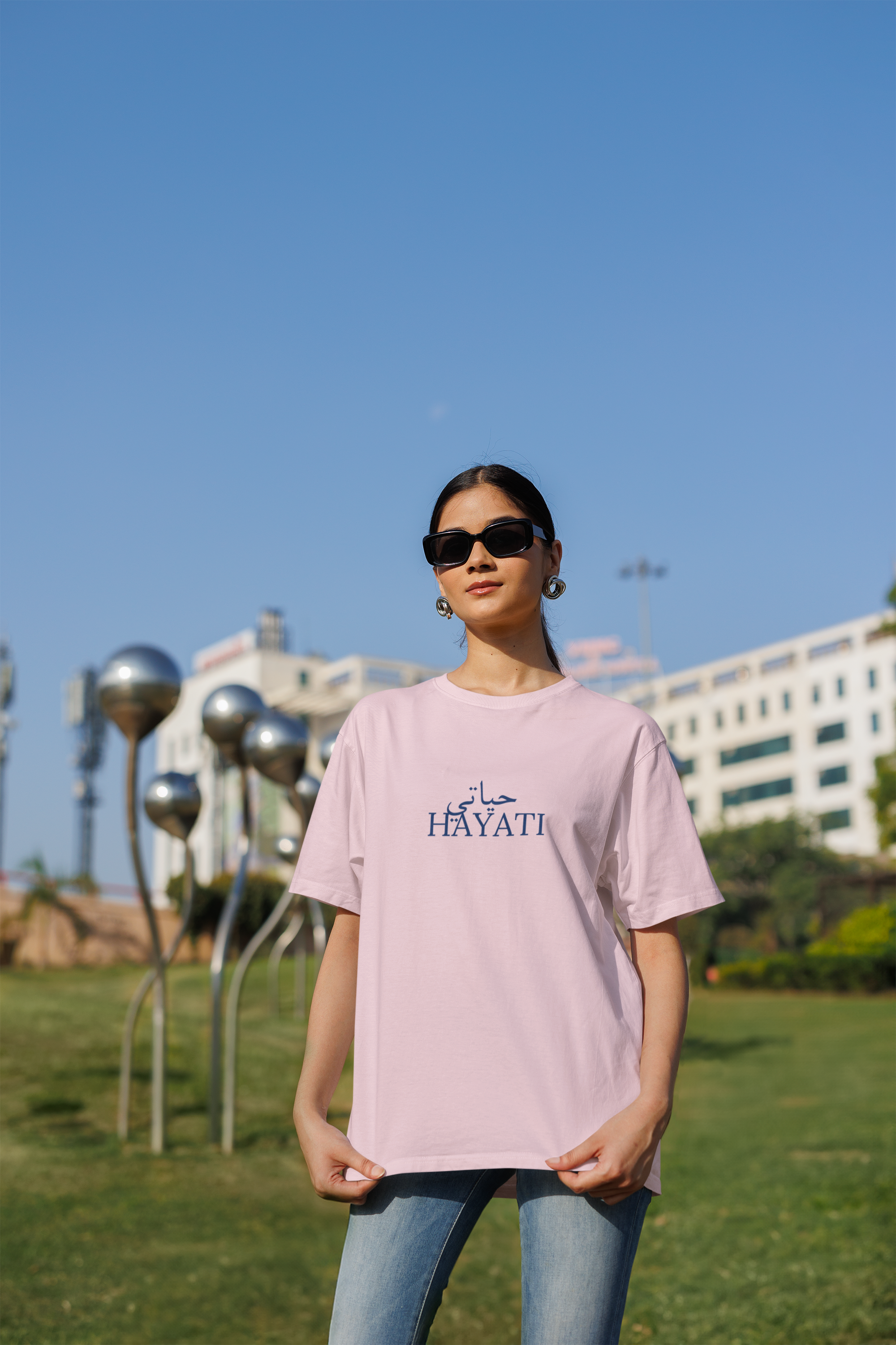 Oversized Blinkstore T-shirt mockup of a Gen Z woman with cool sunglasses. Trendy and casual street style, perfect for modern fashion lovers